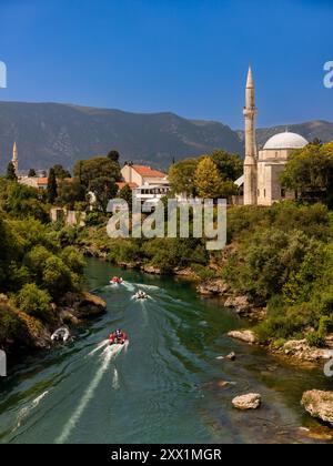 Barche sul fiume Neretva che attraversano Mostar, Bosnia ed Erzegovina, Europa Foto Stock