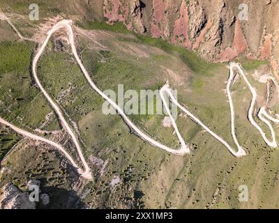 Vista aerea di una tortuosa strada di montagna, passo Kalmak Ashuu, attraverso la lussureggiante vegetazione del Kirghizistan, Asia centrale, Asia Foto Stock