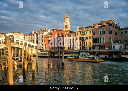 Vista delle case colorate, del ponte di Rialto e del Canal grande con barche al tramonto, Venezia, sito patrimonio dell'umanità dell'UNESCO, Veneto, Italia, Europa Foto Stock