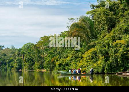 Turisti in escursione sul lago Sandoval contro gli alberi verdi, la riserva nazionale di Tambopata, Puerto Maldonado, madre de Dios, Perù, sud America Foto Stock