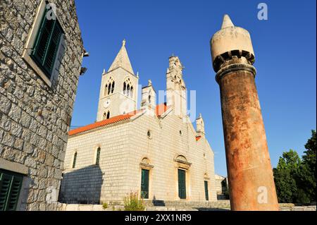 Tipico camino di fronte alla chiesa di San Cosma e San Damiano risalente al XIV secolo, città di Lastovo, isola di Lastovo, Croazia Foto Stock