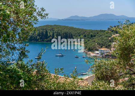 Vista delle barche nella baia di Kalami con sullo sfondo la città di Corfù, Corfù, Mar Ionio, isole greche, Grecia, Europa Foto Stock