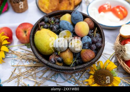 Vari tipi di frutta e verdura in un cestello. prugne, uva, pomodori e cetrioli Foto Stock