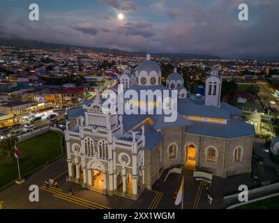 Veduta aerea della Basilica di nostra Signora degli Angeli a Cartago, Costa Rica, illuminata al crepuscolo con una luna piena sullo sfondo Foto Stock