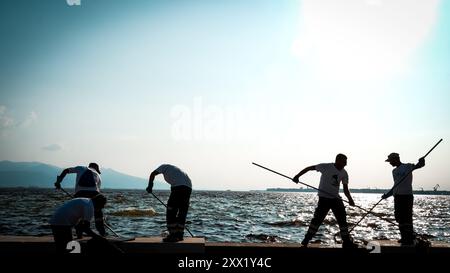 Izmir, Turchia. 21 agosto 2024. Nel Golfo di Smirne si sono verificate morti di massa di pesci a causa dei cambiamenti climatici e dell'inquinamento ambientale. I pesci morti si sono lavati sulla riva mentre gli addetti alle pulizie sono stati visti pulire la costa dai pesci morti. Crediti: İdil Toffolo/Alamy Live News Foto Stock