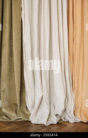 Primo piano delle tende Olive, grigio chiaro e beige sospese fianco a fianco Foto Stock