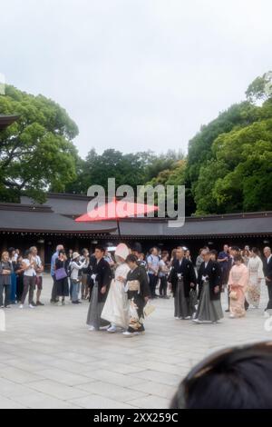 Tradizionale processione nuziale shintoista al santuario Meiji di Tokyo, Giappone, sotto un ombrello rosso. Foto Stock
