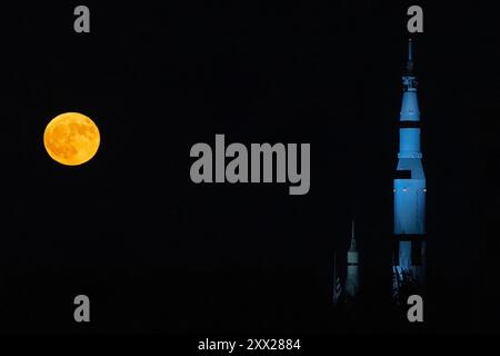 Huntsville, Alabama, Stati Uniti. 19 agosto 2024. Lo Sturgeon Moon sorge dietro una replica di un razzo Saturn V presso lo U.S. Space & Rocket Center di Huntsville, Alabama, lunedì 19 agosto 2024. Più del 99% piena quando si alzò, la luna era una rara combinazione di una luna blu e una superluna, un fenomeno che non si ripeterà fino al 2027. (Credit Image: © Michael DeMocker/NASA/ZUMA Press Wire) SOLO PER USO EDITORIALE! Non per USO commerciale! Foto Stock