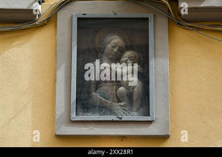 Dettaglio di un tabernacolo con bassorilievo in stucco dipinto della Madonna con bambino in via Faenza, centro storico di Firenze, Toscana, Italia Foto Stock