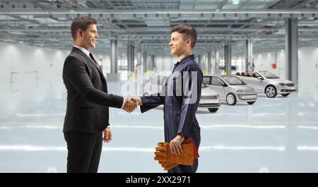 Il manager stringe la mano con un lavoratore di una fabbrica di automobili Foto Stock