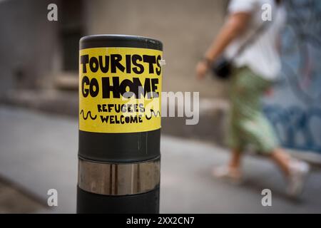 Barcellona, Spagna. 21 agosto 2024. Un graffito che recita "i turisti vanno a casa" si vede su un muro nel centro della città. Con più di 18 milioni di turisti che si prevede visiteranno Barcellona nel 2024, la città sta lottando per trovare un equilibrio tra i benefici economici del turismo durante la stagione turistica e la necessità di mantenere la città vivibile per i residenti locali, che stanno mostrando ostilità verso il turismo di massa e lo sfruttamento della città da parte dell'industria turistica. Credito: SOPA Images Limited/Alamy Live News Foto Stock