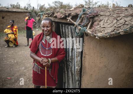 (240822) -- NAROK, 22 agosto 2024 (Xinhua) -- Un abitante Maasai si trova di fronte alla sua casa in un villaggio nella riserva nazionale Masai Mara a Narok, Kenya, il 21 agosto 2024. I Maasai, una delle principali tribù del Kenya, sono principalmente sparsi nelle parti sud e sud-ovest che confinano con la Tanzania. La tribù vive ancora in modo nomade. Il loro insediamento copre le destinazioni turistiche famose in tutto il mondo della riserva nazionale Masai Mara e del Parco nazionale del Serengeti. Con lo sviluppo dell'industria turistica locale, il popolo Maasai ha aperto i propri villaggi per abbracciare i turisti, come un modo per aumentare la loro Foto Stock