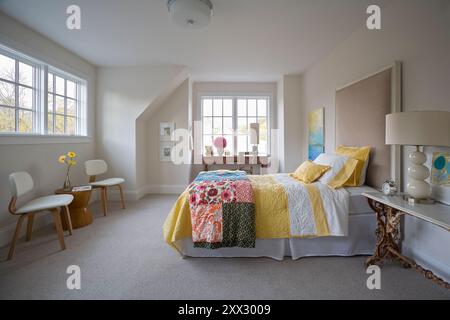 Camera da letto femminile in toni delicati con biancheria da letto giallo brillante Foto Stock