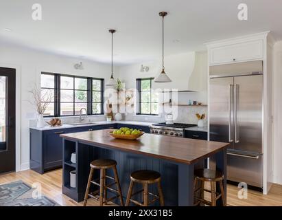 Cucina con armadi blu, ripiani in marmo bianco e ripiani in noce Foto Stock