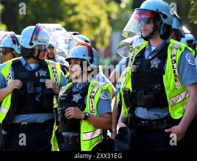 Chicago, Illinois, Stati Uniti. 21 agosto 2024. La polizia di Chicago indossa gli iconici caschi antisommossa azzurri, arriva a fare marcia indietro a centinaia di agenti in bicicletta che fiancheggiavano le strade appena a nord dello United Center mentre un enorme gruppo di manifestanti Pro-Palatini si dirigono verso di loro. (Immagine di credito: © Rob Dicker/ZUMA Press Wire) SOLO PER USO EDITORIALE! Non per USO commerciale! Foto Stock