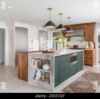 Cucina con armadi in noce, blu e bianco, frigorifero a colonna Sub-Zero e congelatore Foto Stock