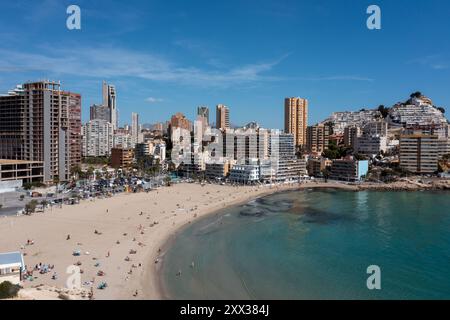 Foto aerea con drone della città di Benidorm in Spagna durante l'estate che mostra la spiaggia conosciuta localmente come Playa de Finestrat e gli hotel e gli appartamenti Foto Stock