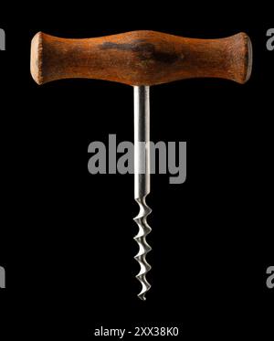 Vecchio cavatappi con manico in legno isolato su sfondo nero. Foto Stock