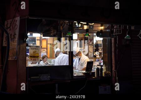 Tokyo, Giappone. 3 agosto 2024. Lo chef giapponese in un ristorante di pesce cucina all'interno di una cucina a vista nel quartiere del mercato di Tsukiji. Tokyo, 3 agosto 2024. - 20240803 PD36437 credito: APA-PictureDesk/Alamy Live News Foto Stock