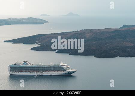 Santorini, Grecia - 8 ottobre 2019: Una vista serena di una nave da crociera che naviga vicino alle isole vulcaniche. Foto Stock