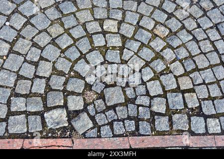 Costruzione, materiali e attrezzature per lavori di costruzione. Pietre bellissime, ciottoli grigi, pietre grigie disposte a terra, muratura Foto Stock