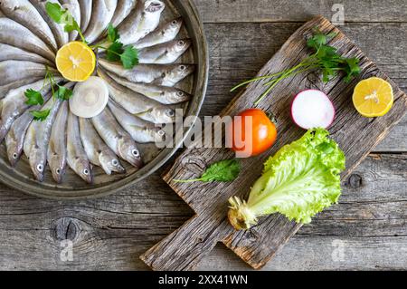 Pesci di eglefino crudi freschi su sfondo rustico, pesce di merlano crudo Foto Stock