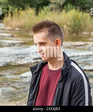 Ritratto di un giovane uomo con un maglione Bordeaux e una giacca nera Foto Stock