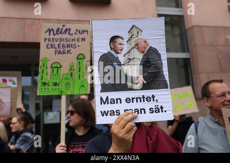 Zwei Demonstrantiennen mit Schildern Nein, zum preußischen Erlebnispark sowie mit foto von AfD-Politiker Björn Höcke und Bundespräsident Frank-Walter Steinmeier am Tag von Potsdam und der Aufschrift Man erntet, era l'uomo sät. während einer Kundgebung gegen die Eröffnung des wiederaufgebauten Turms der Garnisonkirche a Potsdam, 22. Agosto 2024. Eröffnung Garnisonkirche Potsdam *** due manifestanti con i cartelli No, al parco avventura prussiano e con una foto del politico AfD Björn Höcke e del presidente federale Frank Walter Steinmeier il giorno di Potsdam e l'iscrizione si raccoglie ciò che si sta facendo Foto Stock