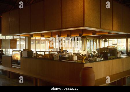 Nusa Dua, Bali, Indonesia - 19 agosto 2024 : un bar con caffè e panetteria in stile giapponese, illuminazione calda e arredi in legno Foto Stock