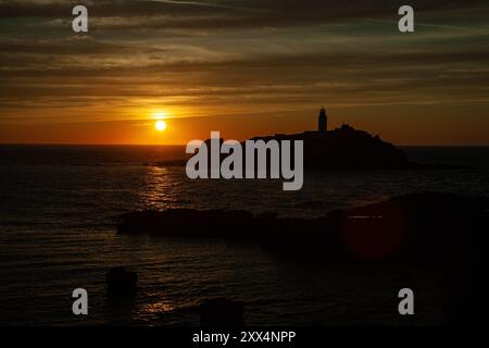 Tramonto sul faro di Godrevy visto dalla scogliera vicino alla costa di Gwithian, Cornovaglia, Regno Unito Foto Stock