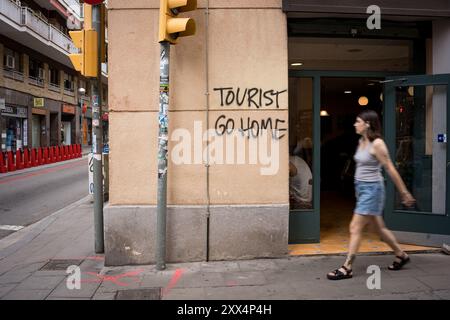 Barcellona, Spagna. 21 agosto 2024. Un graffito che recita "i turisti vanno a casa" si vede su un muro nel centro della città. Con più di 18 milioni di turisti che si prevede visiteranno Barcellona nel 2024, la città e sta lottando per trovare un equilibrio tra i benefici economici del turismo durante la stagione turistica e la necessità di mantenere la città vivibile per i residenti locali, che sono sempre più ostili al turismo di massa e allo sfruttamento della città da parte dell'industria turistica. (Davide Bonaldo/Sipa USA) credito: SIPA USA/Alamy Live News Foto Stock