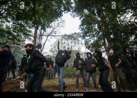 DIMOSTRAZIONE CONTRO LA RATIFICA DEL DISEGNO DI LEGGE ELETTORALE REGIONALE A BANDUNG i manifestanti lanciano pietre durante una manifestazione per proteggere la decisione della Corte costituzionale di fronte alla camera dei rappresentanti regionale di Giava Occidentale, Bandung, Giava Occidentale, Indonesia, 22 agosto 2024. La protesta contro i tentativi di rivedere la legge elettorale regionale da parte della camera dei rappresentanti si è conclusa con una rivolta contro la polizia. IMAGO/KHAIRIZAL MARIS Bandung West Java Indonesia Copyright: XKharizalxMarisxKhairizalxMarisx MANIFESTAZIONE CONTRO LA RATIFICA DEL DISEGNO DI LEGGE ELETTORALE REGIONALE A BANDUNG 11 Foto Stock