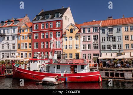 Colorati edifici e barche sul lungomare a Nyhavn, Copenhagen, Danimarca Foto Stock