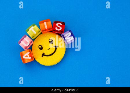 Faccia felice e cubi colorati che formano la parola autismo Foto Stock