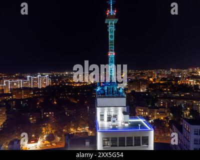 Vista aerea notturna sul tetto dell'edificio Derzhprom con antenna e illuminata città di Charkiv, Ucraina Foto Stock