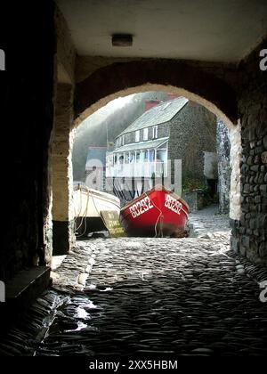 Antiche case che si affacciano sul porto presso il pittoresco villaggio di pescatori di Clovelly sulla costa settentrionale del Devon. La foto è stata scattata da un arco Foto Stock