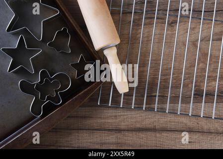 Vista dall'alto di un gruppo di forbici assortite su una teglia da forno con mattarello e griglia di raffreddamento. Foto Stock