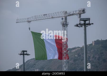 Barcellona, Spagna. 22 agosto 2024. La bandiera della squadra di vela italiana si vede sventolare sopra il porto di Barcellona. La Louis Vuitton Preliminary Regatta 2024 America's Cup ha iniziato le prime gare preliminari questa mattina. I visitatori, i turisti e i residenti hanno potuto godersi gratuitamente la prima gara della competizione dai punti di osservazione sul lungomare e sui grandi schermi situati nelle zone fan. Credito: SOPA Images Limited/Alamy Live News Foto Stock