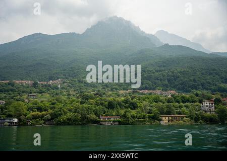 Mandello del Lario, Italia - 08 giugno 2024: Montagne del lago di Como. Piccolo villaggio al centro. Foto Stock
