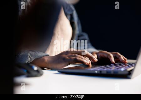 Primo piano di un paio di mani afroamericane che digitano sulla tastiera digitale del computer portatile, navigare in Internet, lavorare online, telelavoro, lavorare come libero professionista sul lavoro. Persona di colore che utilizza la tecnologia moderna. Foto Stock