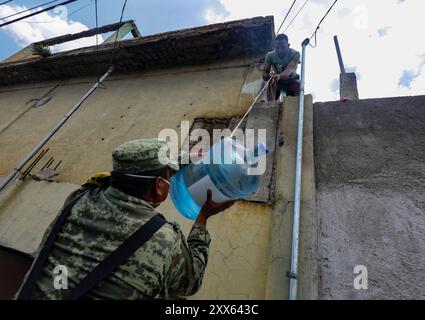 Chalco, Messico. 21 agosto 2024. Elemento de Ejército Mexicano, entregan garrafones de agua potabile, a los afectados por las inundaciones en Chaco en el Estado de México. Ian Robles Credit: SIPA USA/Alamy Live News Foto Stock