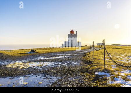 Sentiero che conduce al famoso faro al tramonto sulla spiaggia di Dyrholaey in Islanda nel freddo inverno, vicino a Vik Foto Stock