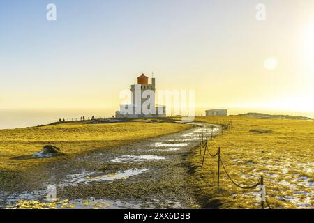 Famoso faro al tramonto sulla spiaggia di Dyrholaey in Islanda in inverno freddo, vicino a Vik Foto Stock