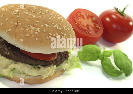 Hamburger con pomodori, lattuga e cipolle su sfondo bianco Foto Stock