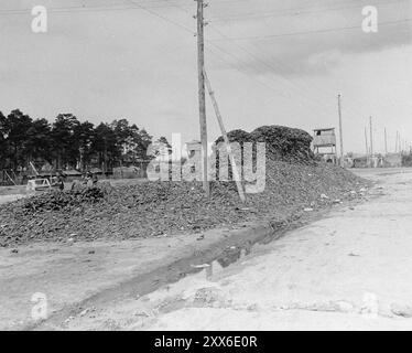 Un mucchio di scarpe delle vittime sulla strada principale del campo di concentramento di Bergen-Belsen. La foto è datata 28 aprile 1945, due settimane dopo la liberazione del campo. La posizione del campo nella Germania occidentale significò che migliaia di persone furono inviate lì mentre l'est cadde. 18000 persone sono morte solo nel marzo 1945, e 10000 sono morte nelle due settimane dopo la liberazione. Sono morti di malattia e negligenza piuttosto che di abusi sistematici visti altrove. Foto Stock