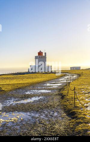 Sentiero che conduce al famoso faro al tramonto sulla spiaggia di Dyrholaey in Islanda nel freddo inverno, vicino a Vik Foto Stock