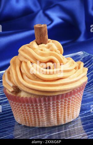 La carota e la cannella cupcake su un piatto di vetro su uno sfondo blu Foto Stock