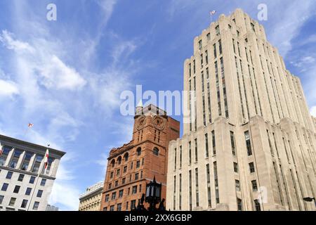 Aldred Building, in stile art deco sulla destra e New York Life Building, il primo grattacielo di Montreal sulla sinistra in Place d'Armes, a Vieux, M. Foto Stock