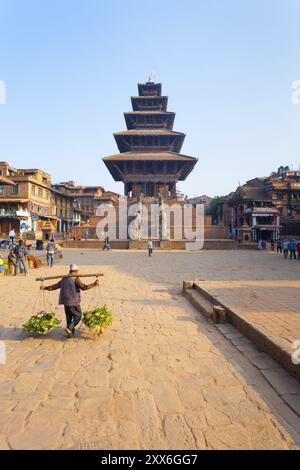 Bhaktapur, Nepal, 31 ottobre 2013: Uomo nepalese che trasporta verdure oltre la Pagoda Nyatapola intatta in piazza Bhaktapur Taumadhi prima del 2015 Gorkha Foto Stock