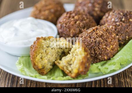 Falafel fatto in casa (primo piano, messa a fuoco selettiva) su sfondo in legno Foto Stock